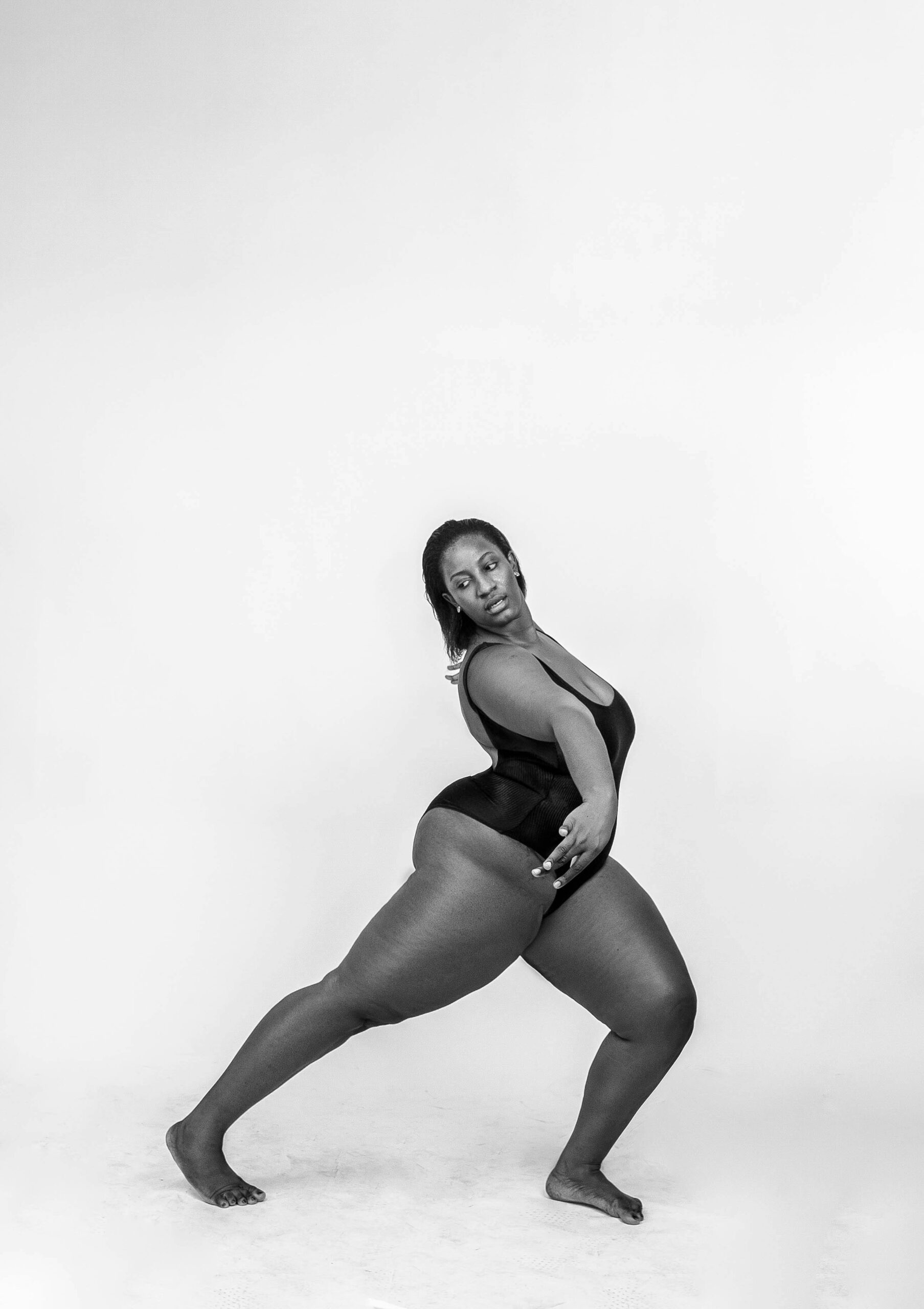 Black and white photo of a female model posing gracefully in a swimsuit.