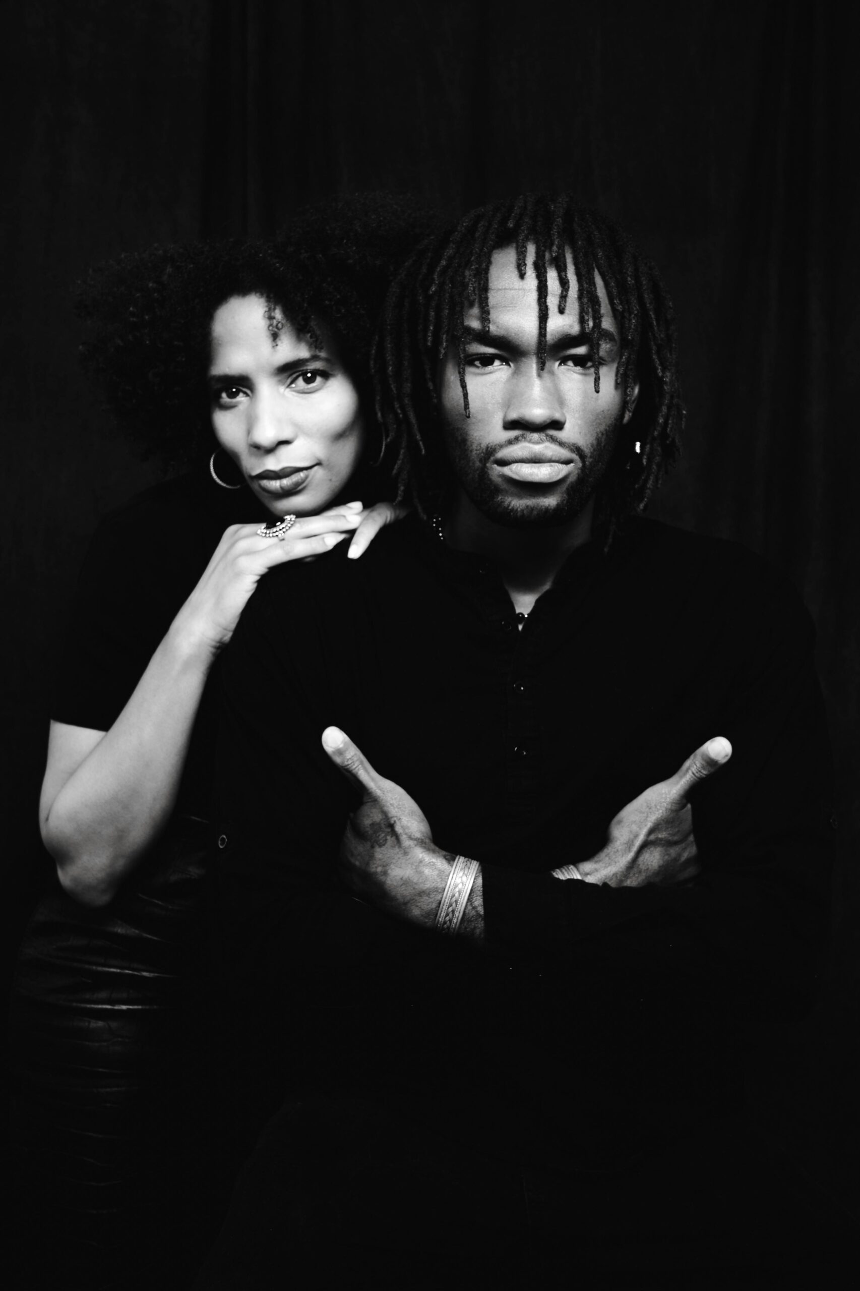 Striking grayscale portrait of a couple posing together in a studio setting.