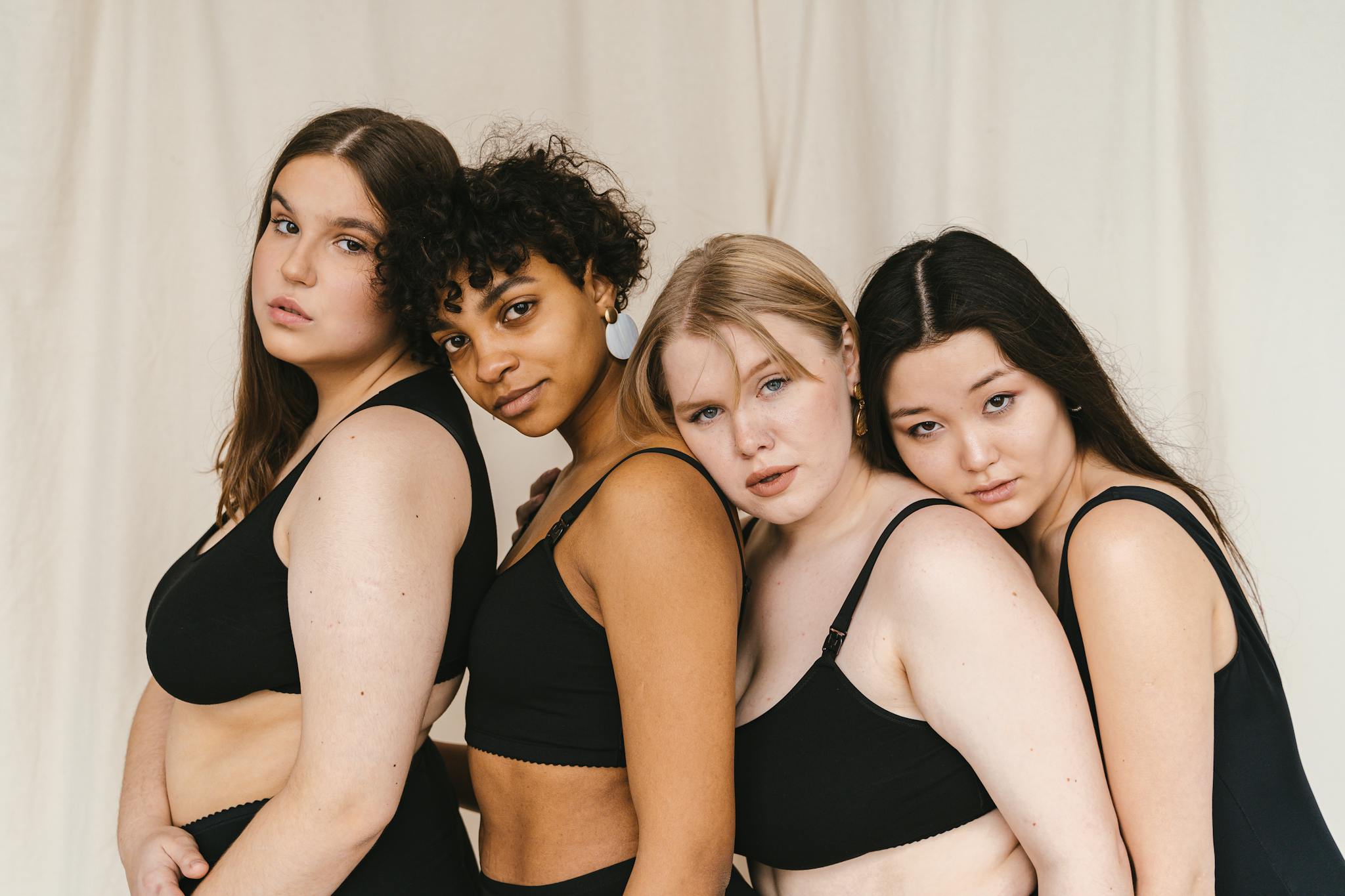 Portrait of a diverse group of women embracing body positivity in a studio setting, promoting inclusivity.