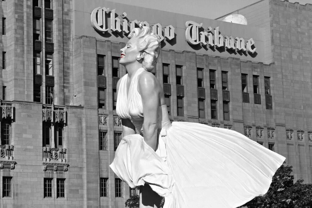 pexels-photo-26776845-26776845 Black and white photo of Marilyn Monroe statue in front of Chicago Tribune building.