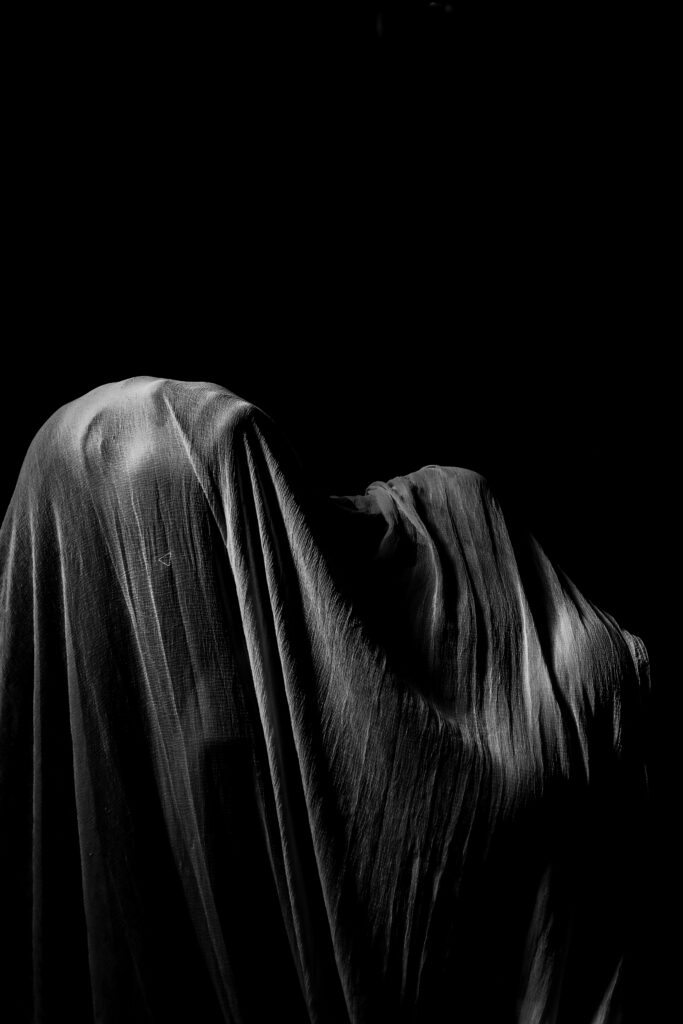 pexels-photo-3111251-3111251 A captivating monochrome image of a draped figure against a dark background.